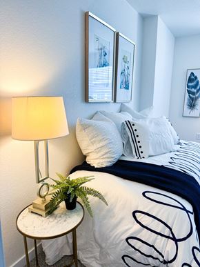 Denver apartment for rent - a bedroom with a bed and a table with a lamp and pictures on the wall