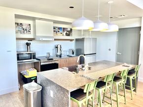 Denver apartment for rent - a view of a kitchen with a large island and green bar stools
