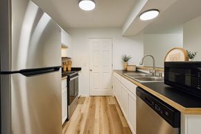 Rogers apartment for rent - A modern kitchen with a stainless steel refrigerator and wooden flooring.