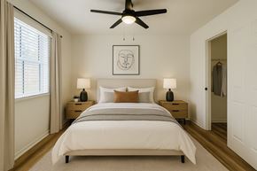 Rogers apartment for rent - A bedroom with a large bed and a ceiling fan.