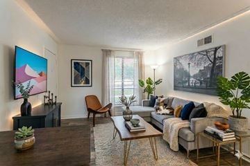 Memphis apartment for rent - A living room with a grey couch, a wooden coffee table, and a painting on the wall.