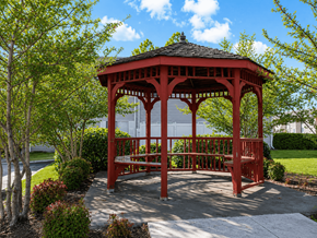 Broken Arrow townhouse for rent - A red gazebo is surrounded by trees and bushes.