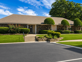 Broken Arrow townhouse for rent - A house with a grey roof and a white door is surrounded by greenery.