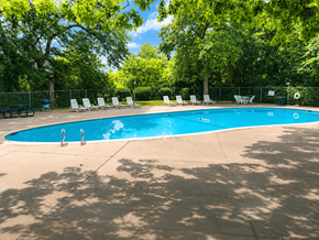 Broken Arrow townhouse for rent - A swimming pool surrounded by trees and chairs.