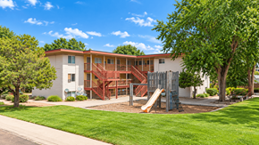 Lakewood apartment for rent - A playground with a slide is in front of a two-story building.