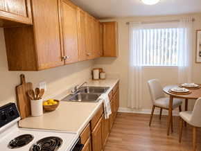 Lakewood apartment for rent - A kitchen with wooden cabinets and a white stove top oven.