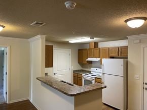 Cleveland apartment for rent - A kitchen with white appliances and wooden cabinets.