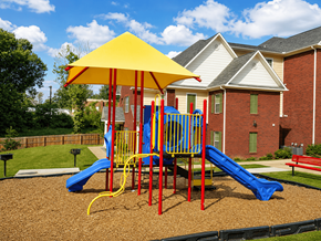 Memphis apartment for rent - A playground with a yellow umbrella and a blue slide.