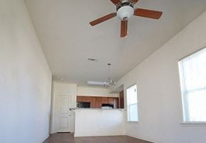 New Albany apartment for rent - an empty living room with a ceiling fan and a kitchen