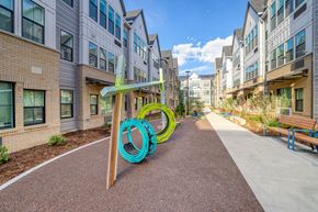 Aurora apartment for rent - A playground with a slide in the middle of a walkway between buildings.