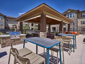 Edinburg apartment for rent - A patio with a table and chairs is surrounded by apartment buildings.