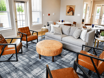 Lebanon apartment for rent - A living room with a grey couch and brown chairs.
