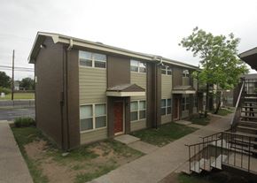 Austin townhouse for rent - A brown and beige apartment building with a red door.