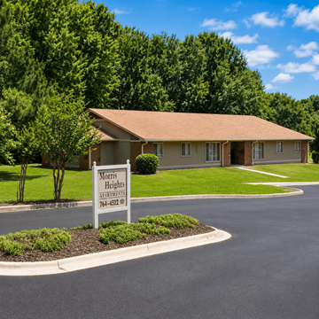 Statesboro apartment for rent - A sign for Morris Heights Apartments is in the foreground of a well-manicured lawn.