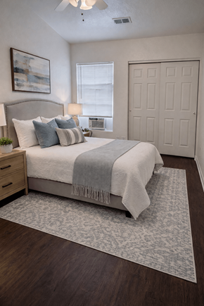 Denver apartment for rent - A bedroom with a bed, a ceiling fan, and a rug.