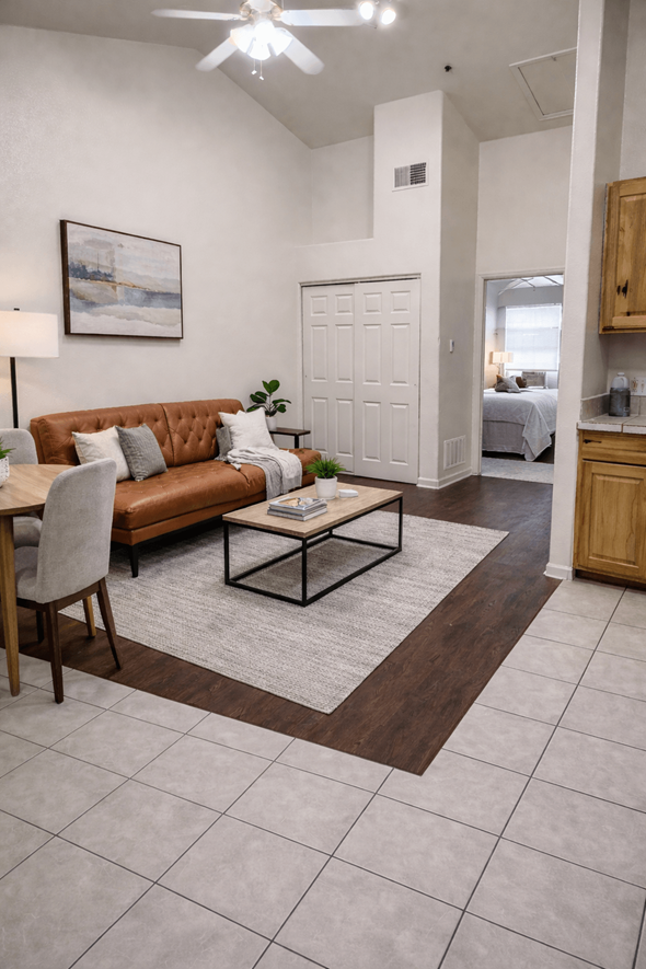 Denver apartment for rent - A living room with a brown couch and a white ceiling fan.