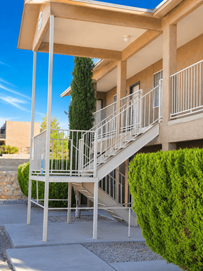 El Paso apartment for rent - A staircase with a metal railing and a green bush on the side.