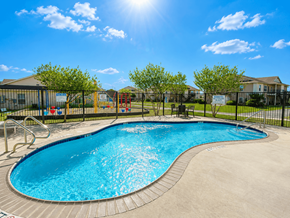 Kerrville apartment for rent - A sunny day at a pool with a slide and a playground.
