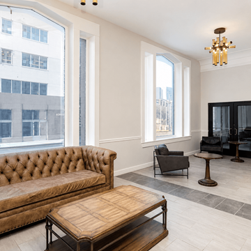 Chattanooga apartment for rent - A brown tufted couch sits in a living room with a wooden coffee table in front of it.