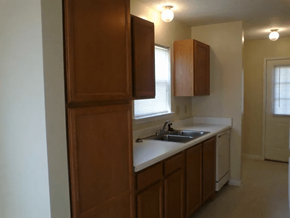 Alamo apartment for rent - an empty kitchen with a sink and wooden cabinets