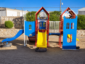 El Paso apartment for rent - A playground with a blue slide and two red and blue houses.
