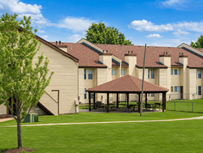 Tulsa apartment for rent - A tree stands in front of a building with a covered patio.