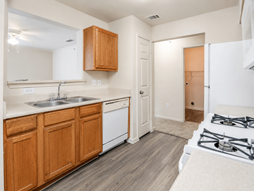 Austin apartment for rent - A kitchen with wooden cabinets and a white stove top oven.