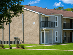 Marrero apartment for rent - A brick building with a balcony and a sign on the wall.