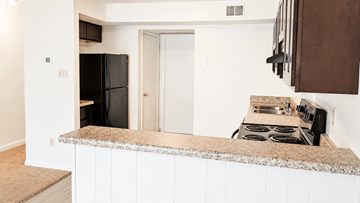 Lexington townhouse for rent - A kitchen with a black fridge and stove top oven.
