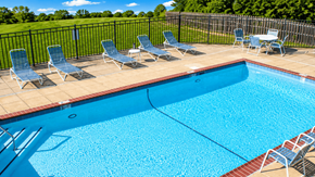 Lexington townhouse for rent - A pool surrounded by chairs and a fence.