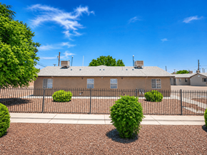 El Paso apartment for rent - A building with a black fence and bushes in front.