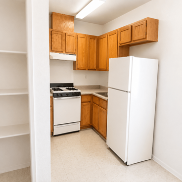 El Paso apartment for rent - A kitchen with white appliances and wooden cabinets.