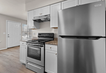 A kitchen with stainless steel appliances and white cabinets