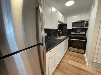 A kitchen with stainless steel appliances and white cabinets