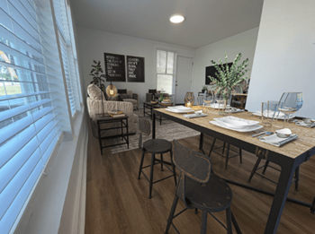 A dining room and living room with a table and chairs