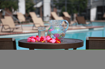 A vase with flowers on a table near a swimming pool