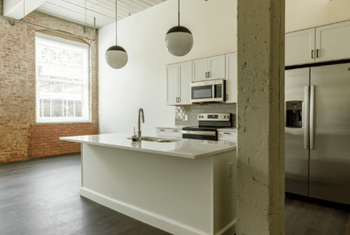 A white kitchen with a sink and a refrigerator