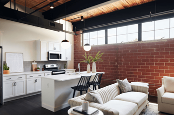 An open kitchen and living room with a brick wall