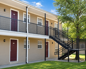 Baton Rouge townhouse for rent - A building with a red door and a black metal staircase.