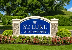 Richmond apartment for rent - A sign for St. Luke Apartments is surrounded by flowers and greenery.
