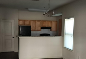 Tupelo townhouse for rent - an empty kitchen with wooden cabinets and a white counter top