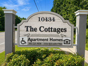 Little Rock apartment for rent - A sign for The Cottages Apartment Homes with a phone number and TTY number.