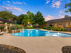 Buda townhouse for rent - A swimming pool surrounded by a stone patio and a house in the background.