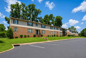 Forsyth apartment for rent - A large building with a parking lot in front of it.