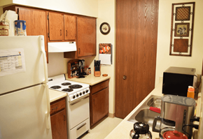 Rockford apartment for rent - A kitchen with a white fridge, white stove, and a white oven.