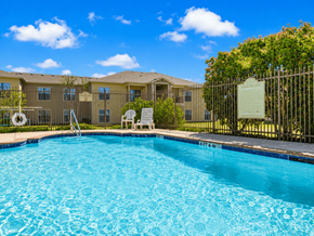 Cleburne townhouse for rent - A pool in front of a building with a sign on a fence.