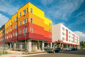 Denver apartment for rent - A multi-story building with a yellow, red, and white exterior.