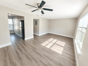 Leavenworth apartment for rent - A spacious room with a ceiling fan and a refrigerator.