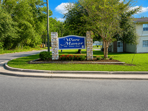 Waycross apartment for rent - A sign that says "Ware Motor" stands in front of a house.