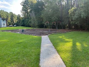 Waycross apartment for rent - A playground with a swing set and a white line in the middle of a grassy area.